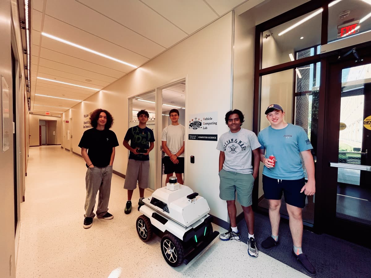 A student team with the robotic vehicle outside the Vehicle Computing Lab