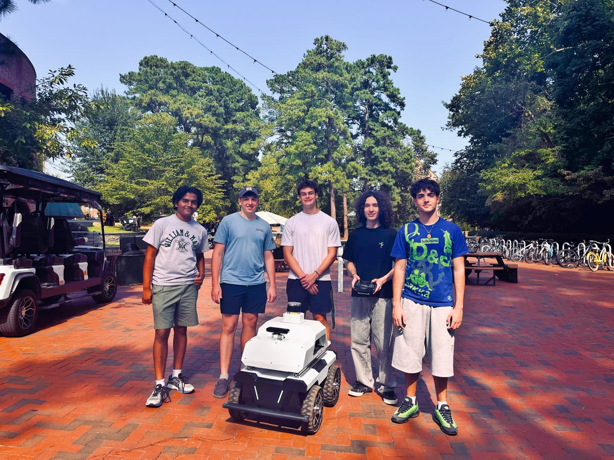 A student team testing a robot vehicle outdoors on campus